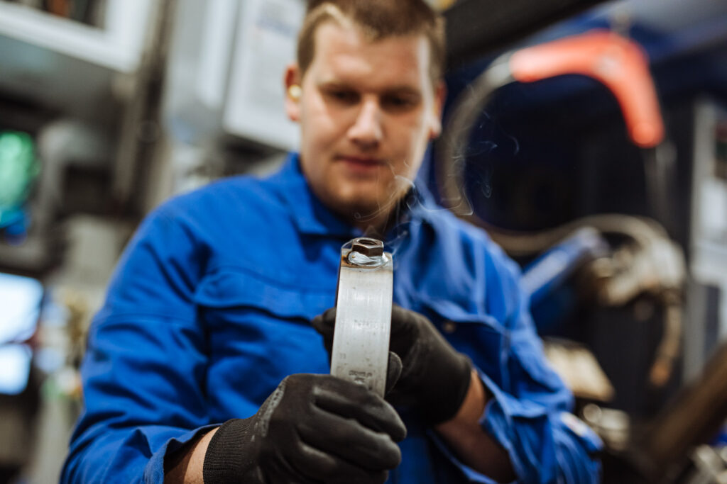 Eine Person kontrolliert die Schweißnaht. Industriefoto aus einem Fotoshooting.